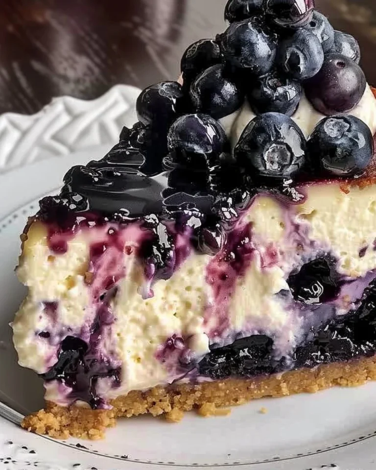 Delicious blueberry cheesecake topped with fresh blueberries and cream
