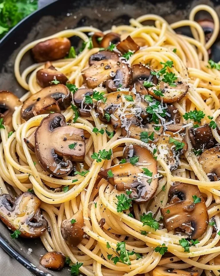 A plate of Mushroom Spaghetti topped with fresh herbs and parmesan cheese.