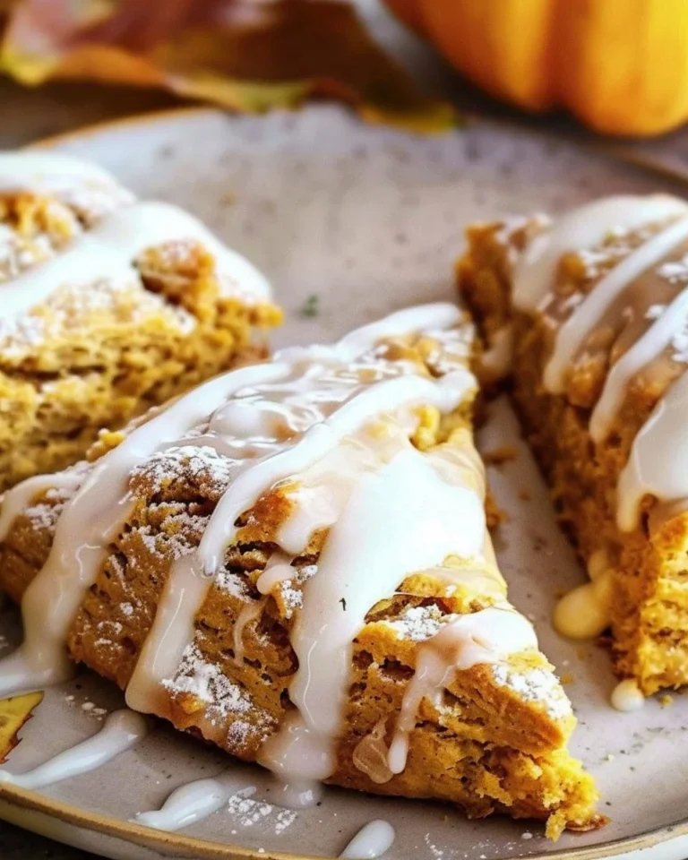 Delicious glazed pumpkin scones with a drizzle of icing on a plate