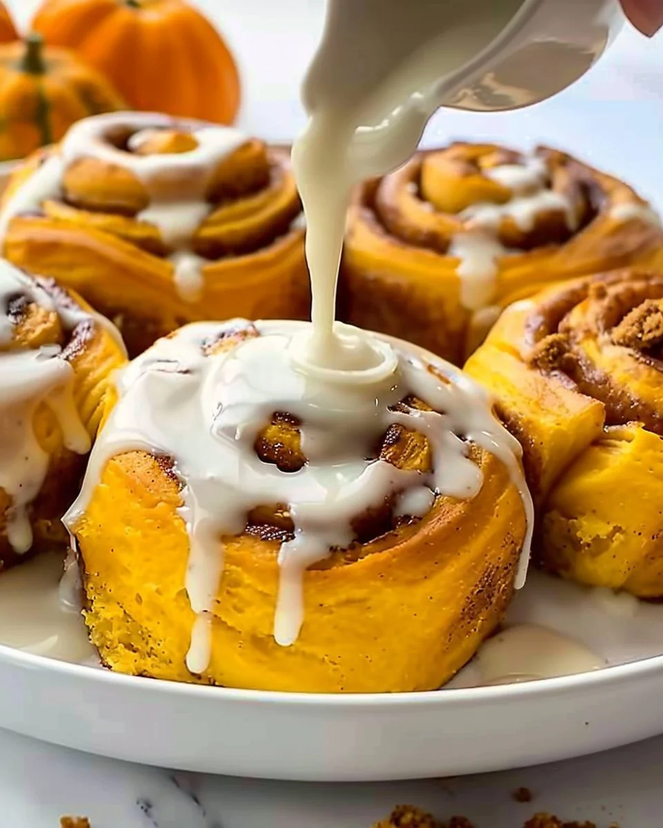 Delicious Pumpkin Cinnamon Rolls topped with cream cheese frosting